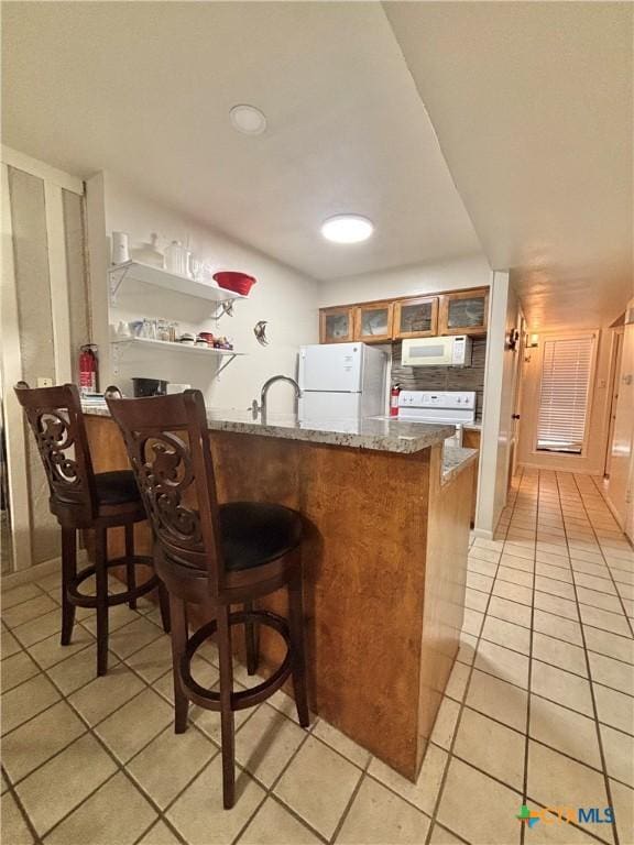 bar featuring sink, light tile patterned floors, and white appliances