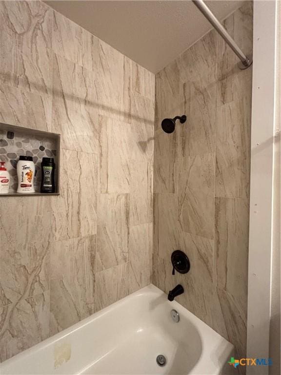 bathroom featuring tiled shower / bath