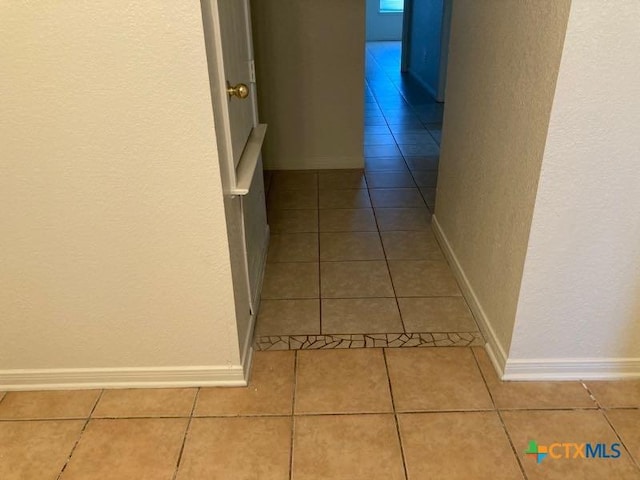 hall with light tile patterned floors