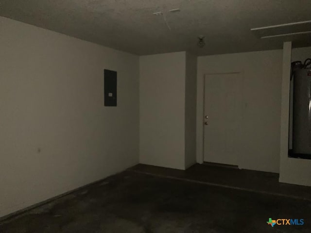 unfurnished room with electric panel and concrete floors