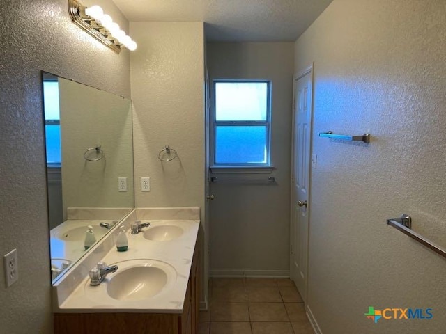 bathroom with tile patterned flooring, vanity, and a textured ceiling