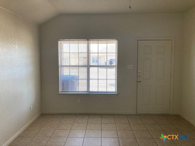 tiled foyer featuring vaulted ceiling