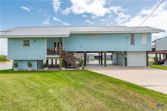 77 Sailfish Lndg, Port Lavaca, TX 77979 - view of front facade featuring a garage, a front yard, stairway, a metal roof, and concrete driveway
