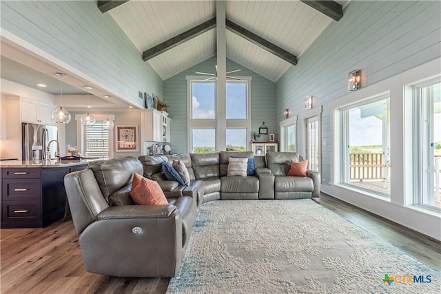 77 Sailfish Lndg, Port Lavaca, TX 77979 - living room featuring high vaulted ceiling, wood walls, healthy amount of natural light, wood finished floors, and beam ceiling