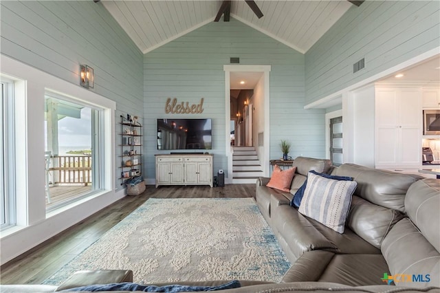 77 Sailfish Lndg, Port Lavaca, TX 77979 - living room with wooden walls, dark wood-style flooring, stairway, a ceiling fan, and beamed ceiling