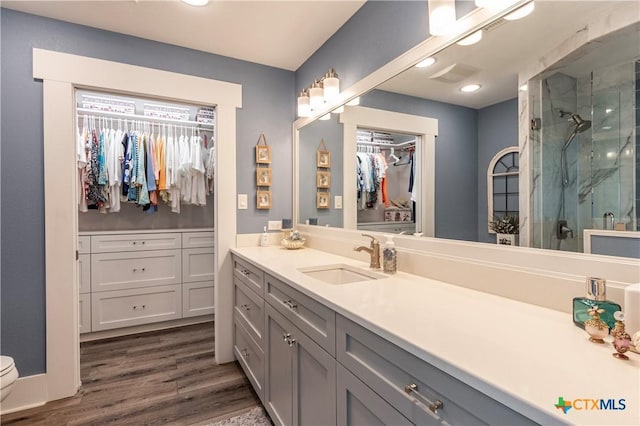 77 Sailfish Lndg, Port Lavaca, TX 77979 - bathroom with vanity, a walk in closet, a marble finish shower, wood finished floors, and recessed lighting