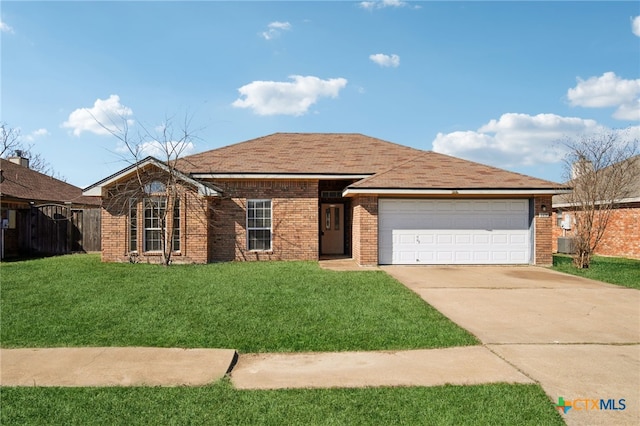 ranch-style house with a garage, brick siding, fence, driveway, and a front yard