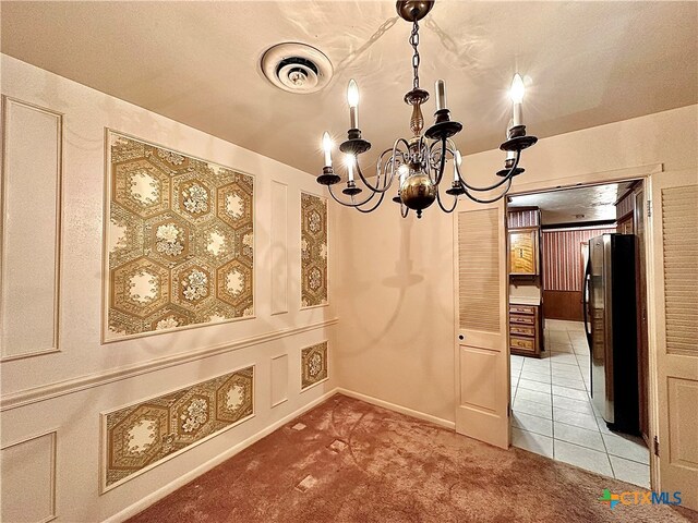 unfurnished dining area with a chandelier and carpet floors