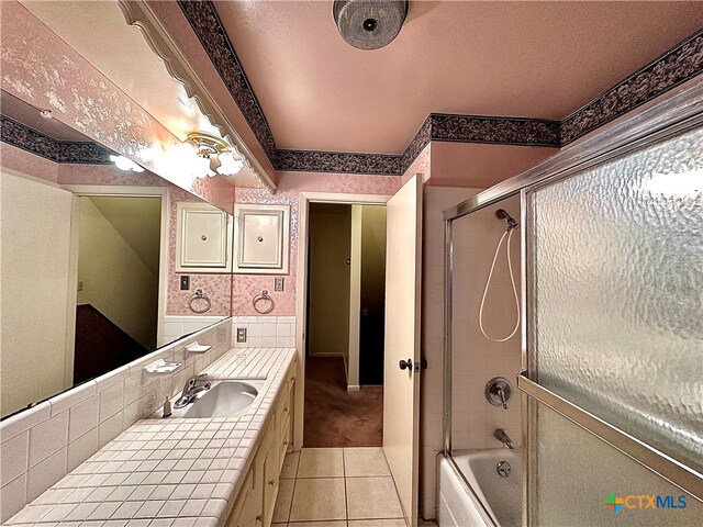 bathroom featuring vanity, bath / shower combo with glass door, and tile patterned floors