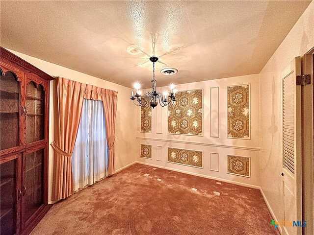 unfurnished dining area with a textured ceiling, carpet flooring, and a notable chandelier