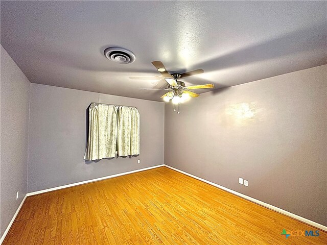 spare room featuring wood-type flooring, ceiling fan, and a textured ceiling