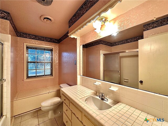 bathroom with vanity, a shower with door, tile patterned flooring, and toilet