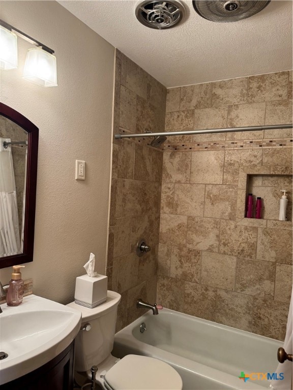 full bathroom featuring tiled shower / bath combo, toilet, a textured ceiling, and vanity