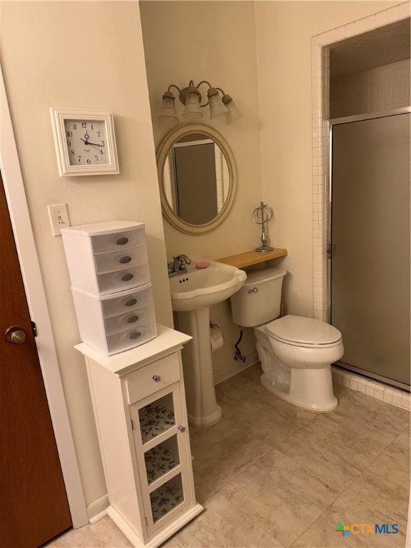 bathroom featuring toilet, an enclosed shower, and sink