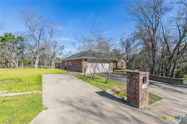 view of property exterior featuring driveway, an attached garage, a lawn, and brick siding