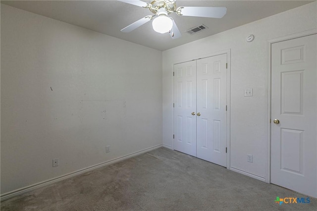 unfurnished bedroom with baseboards, visible vents, ceiling fan, carpet, and a closet