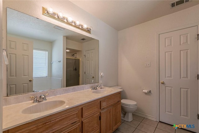 bathroom with a stall shower, tile patterned flooring, a sink, and visible vents