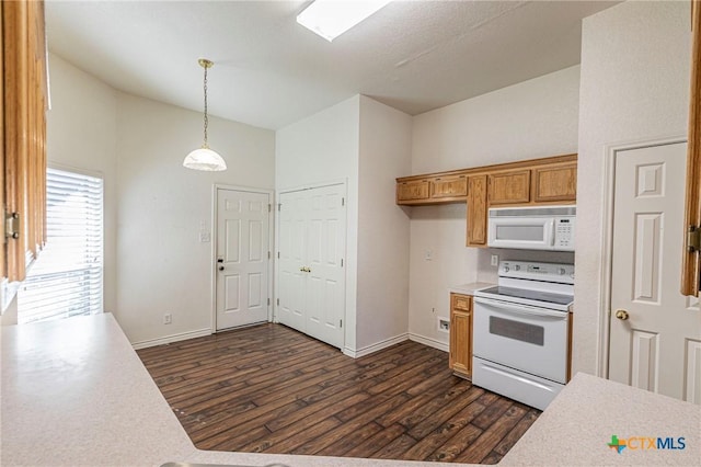 kitchen featuring white appliances, brown cabinetry, dark wood-type flooring, decorative light fixtures, and light countertops