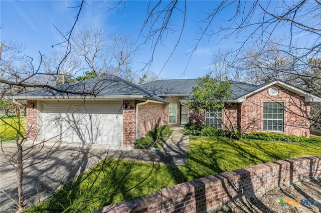 ranch-style home featuring driveway, a garage, a shingled roof, brick siding, and a front yard