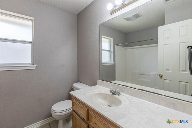 bathroom with baseboards, visible vents, a textured wall, toilet, and vanity