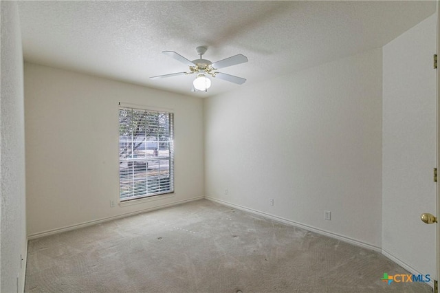 unfurnished room with carpet floors, baseboards, a ceiling fan, and a textured ceiling