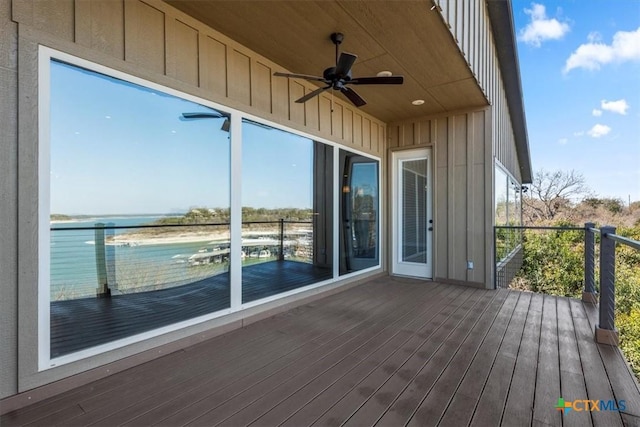 deck with a water view and ceiling fan