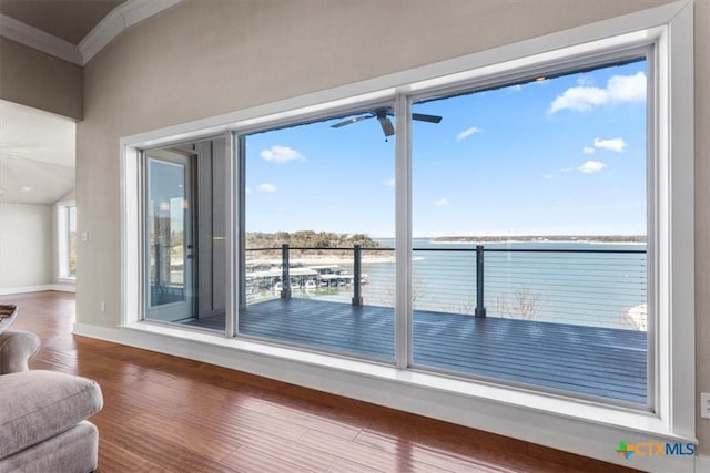 doorway with crown molding, hardwood / wood-style flooring, ceiling fan, and a water view