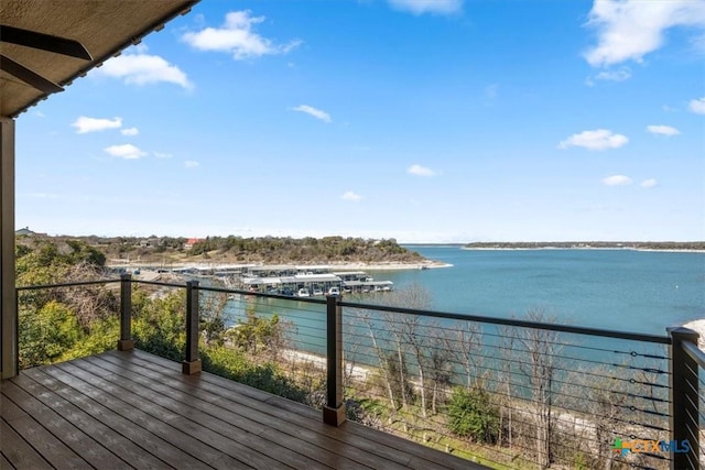 wooden terrace with a water view and ceiling fan