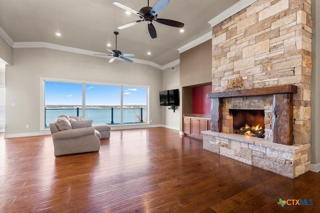 unfurnished living room featuring crown molding, hardwood / wood-style flooring, a fireplace, and a towering ceiling