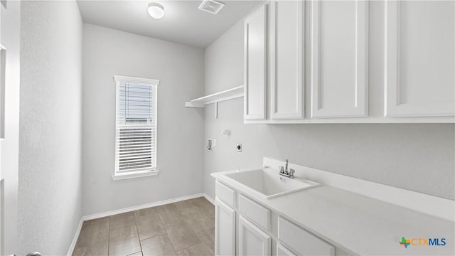 laundry area with cabinet space, visible vents, hookup for a washing machine, hookup for an electric dryer, and a sink