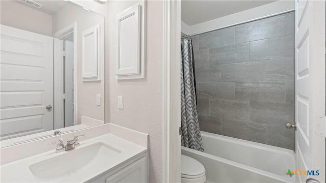 bathroom featuring shower / bath combo, visible vents, vanity, and toilet