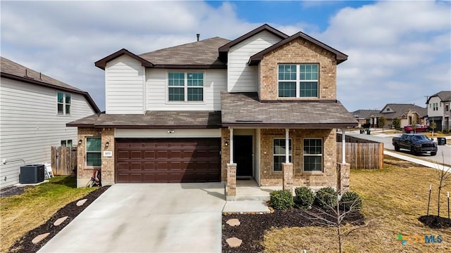 craftsman inspired home with driveway, an attached garage, fence, central air condition unit, and brick siding