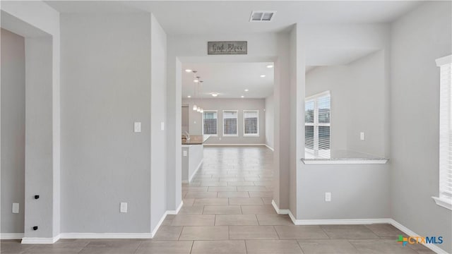 hallway with recessed lighting, tile patterned flooring, visible vents, and baseboards