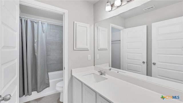 bathroom featuring visible vents, shower / tub combo with curtain, vanity, and toilet