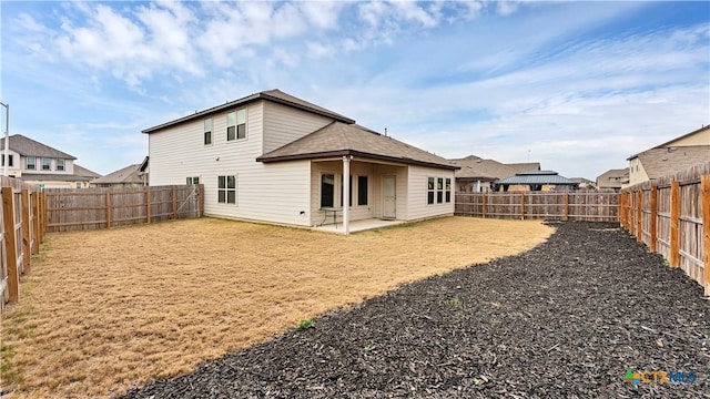 rear view of property featuring a patio area, a fenced backyard, and a lawn