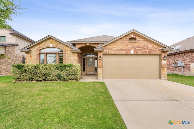 1328 Blue Leaf Dr, Temple, TX 76502 - ranch-style home featuring a front lawn, stone siding, a garage, brick siding, and driveway