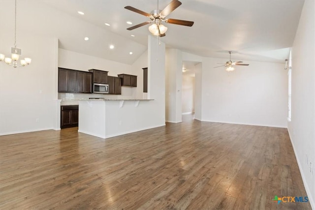 1328 Blue Leaf Dr, Temple, TX 76502 - unfurnished living room with high vaulted ceiling, ceiling fan with notable chandelier, recessed lighting, baseboards, and wood finished floors