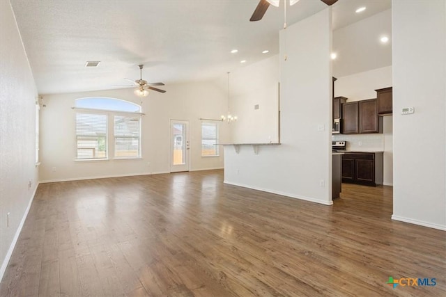 1328 Blue Leaf Dr, Temple, TX 76502 - unfurnished living room featuring baseboards, ceiling fan with notable chandelier, wood finished floors, and lofted ceiling