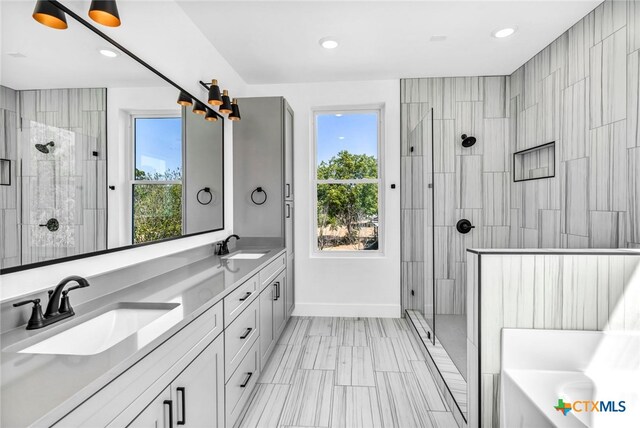 bathroom featuring vanity and independent shower and bath