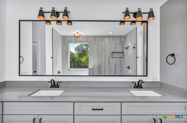 bathroom featuring a tile shower and vanity