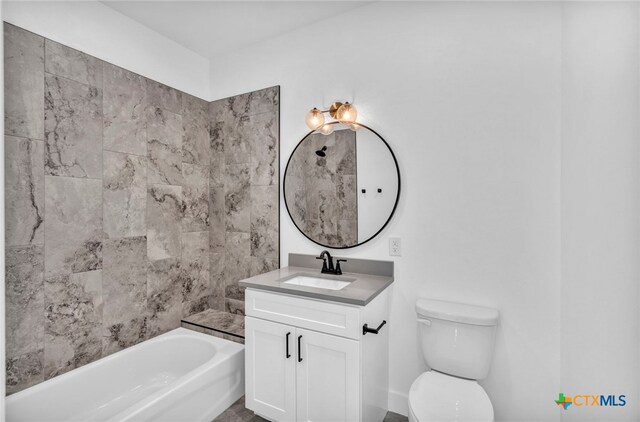 full bathroom featuring vanity, tiled shower / bath combo, and toilet