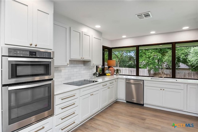 9 Mission Trce, New Braunfels, TX 78130 - kitchen featuring stainless steel appliances, backsplash, white cabinetry, recessed lighting, and light wood-type flooring