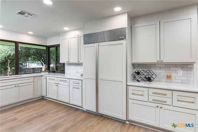 9 Mission Trce, New Braunfels, TX 78130 - kitchen with paneled built in refrigerator, light countertops, recessed lighting, tasteful backsplash, and light wood finished floors