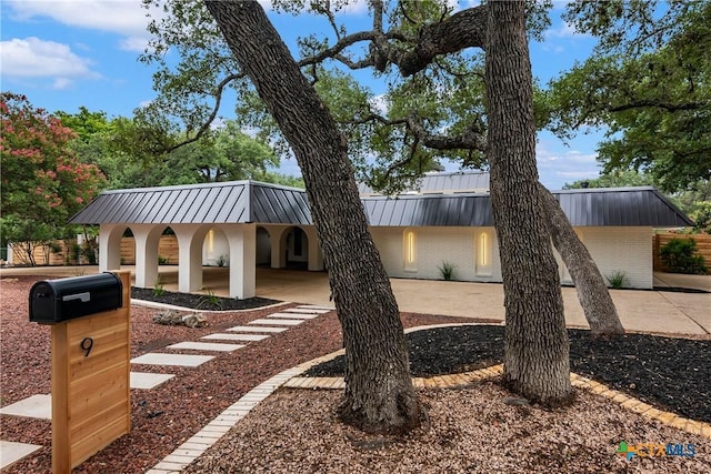 9 Mission Trce, New Braunfels, TX 78130 - view of front of property with a metal roof, a standing seam roof, brick siding, and a patio