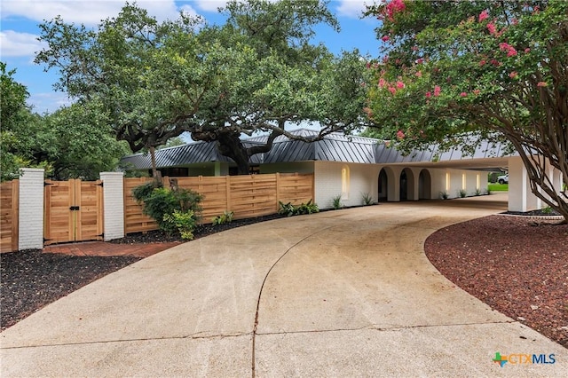 9 Mission Trce, New Braunfels, TX 78130 - view of front of house featuring a gate, driveway, a metal roof, and a standing seam roof
