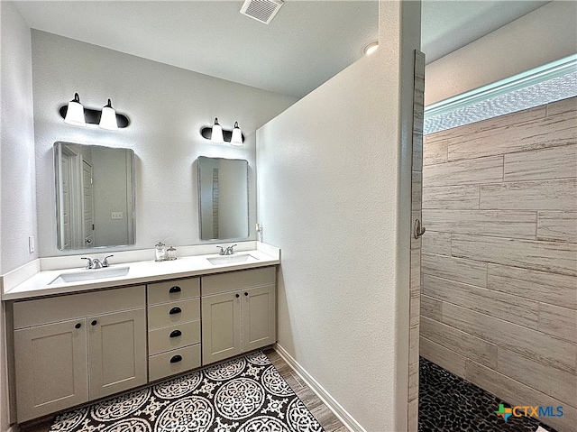 bathroom with vanity and tiled shower