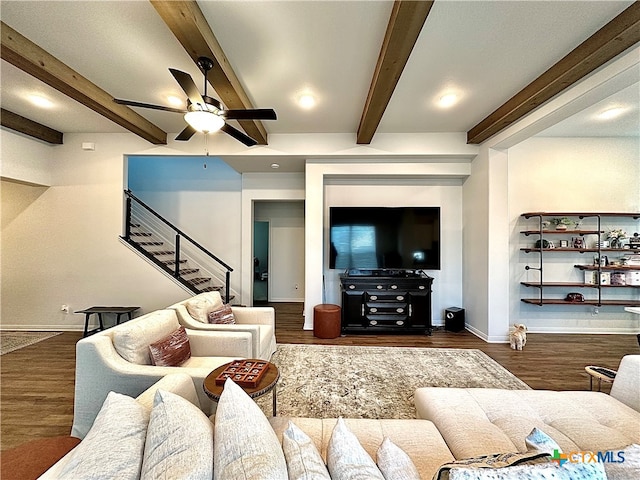 living room featuring dark wood-type flooring, beamed ceiling, and ceiling fan