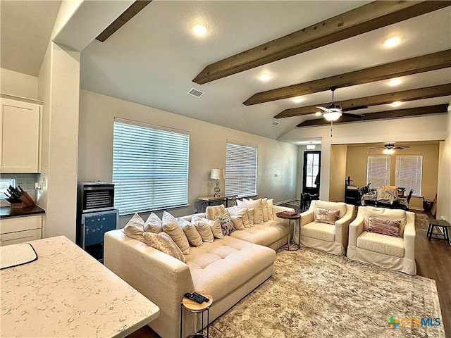 living room with hardwood / wood-style floors, ceiling fan, and beam ceiling