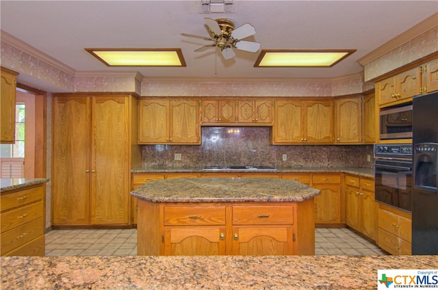 kitchen featuring light stone counters, black appliances, a kitchen island, and ornamental molding