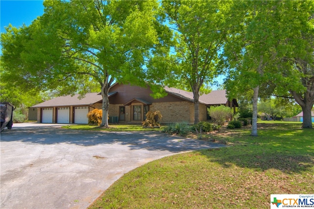 ranch-style home with a garage and a front yard